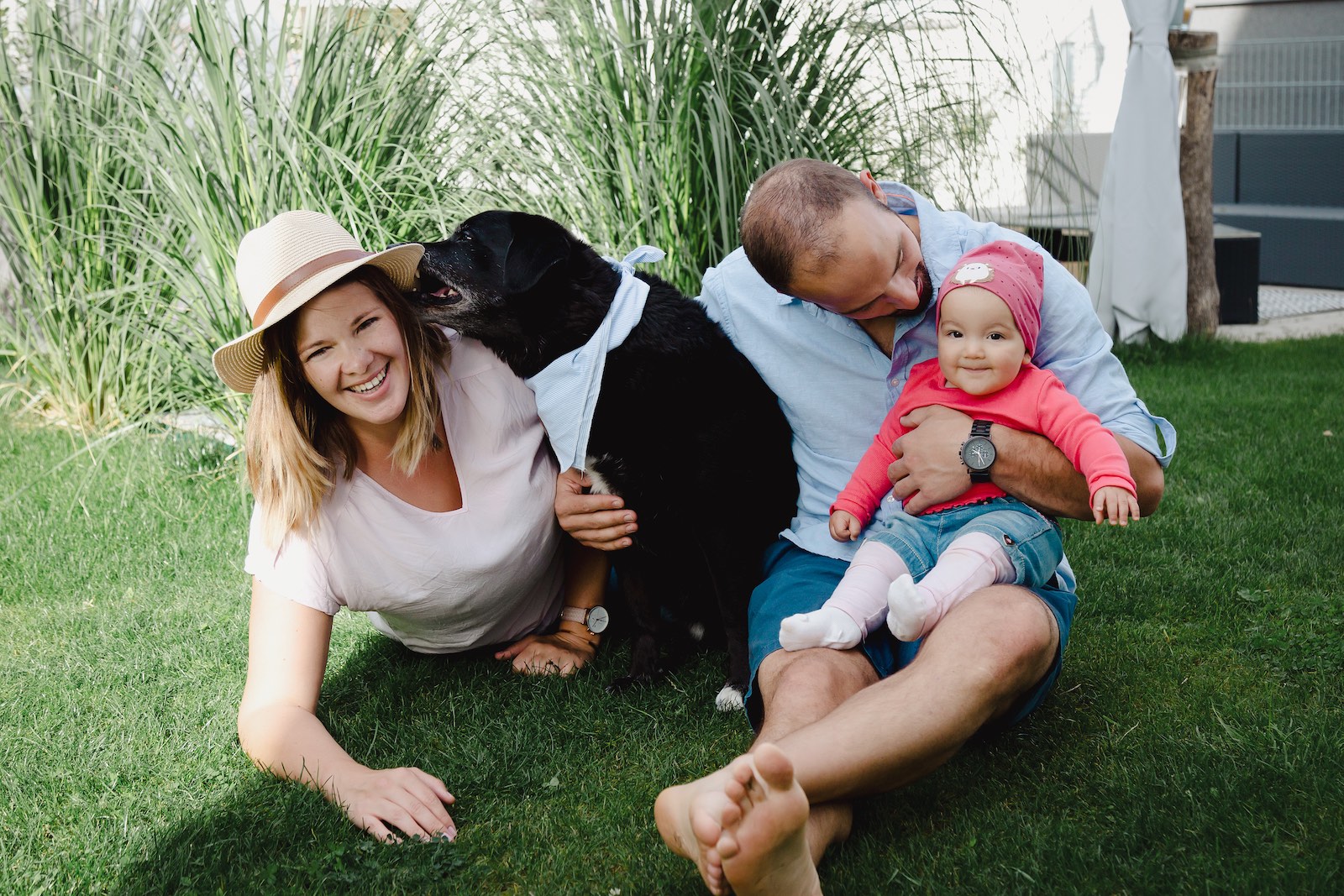 Familie auf dem Rasen ihres Gartens mit Hund
