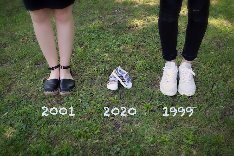 Beine eines Paars mit Babyschuhen in der Mitte