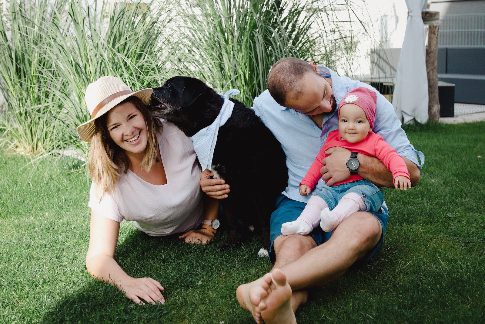 Familie auf dem Rasen ihres Gartens mit Hund