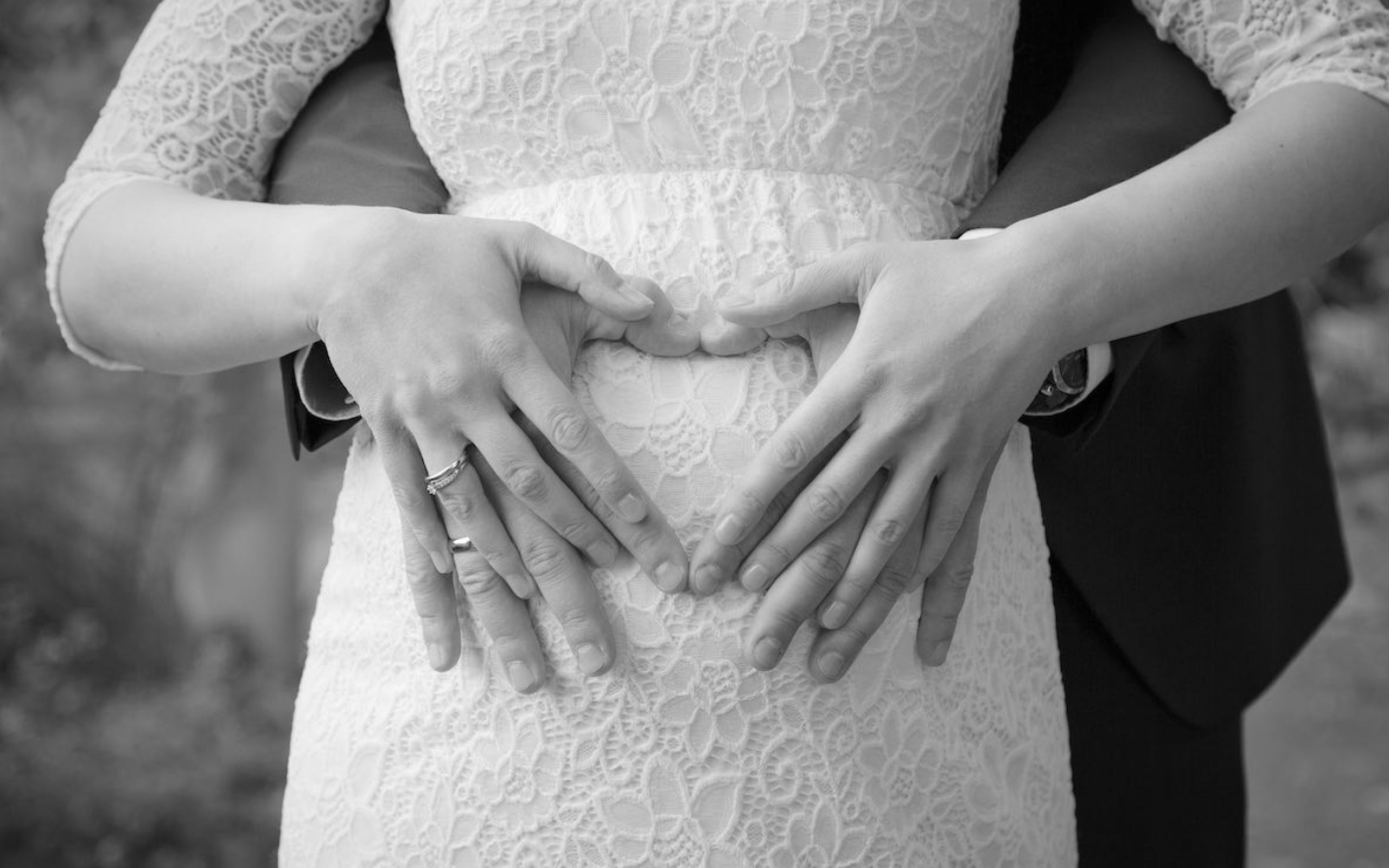 Brautpaar, deren Hände übereinander liegen und ein Herz formen